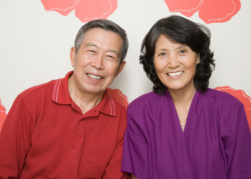 Senior Asian couple smiling portraying natural-looking dentures