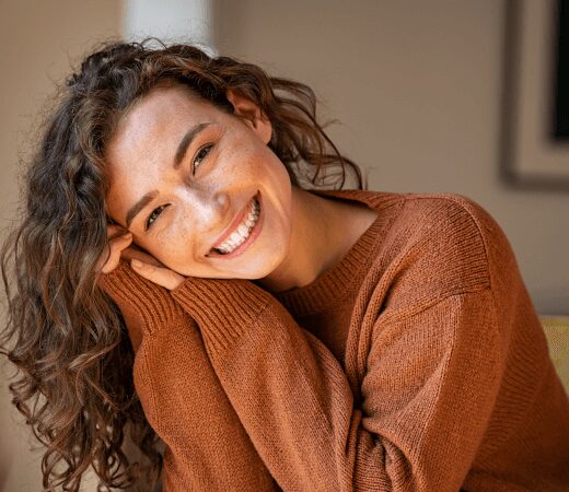 Young woman with wavy brunette hair smiling