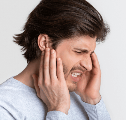 Man holding his ear portraying radiating ear pain, which salivary gland stones do not cause